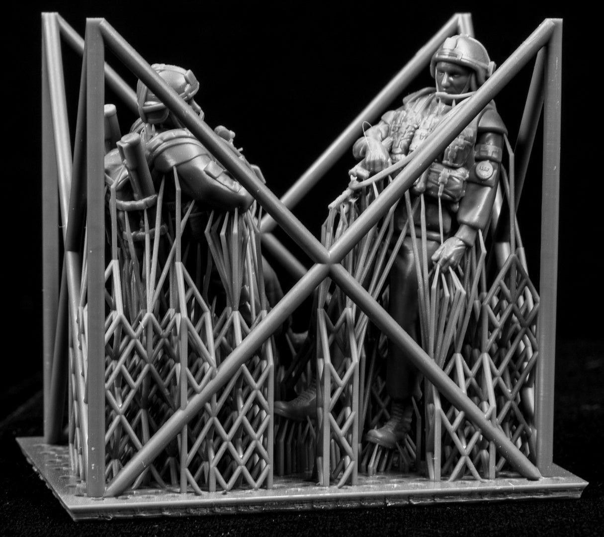 Two miniature figures of soldiers with gear inside a frame on a black background