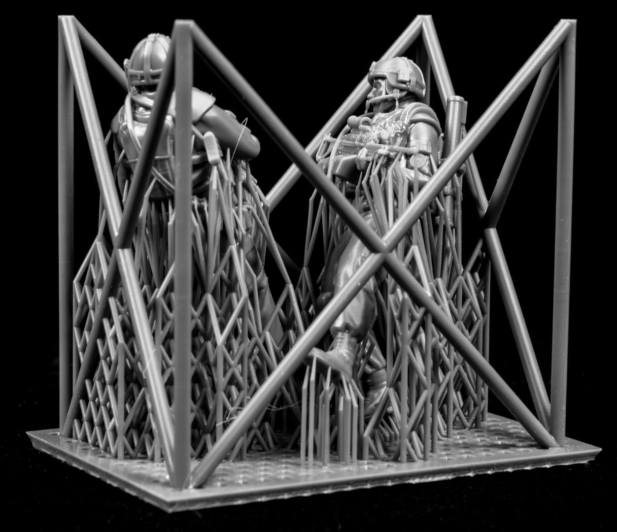 Two miniature figures of soldiers with gear inside a frame on a black background