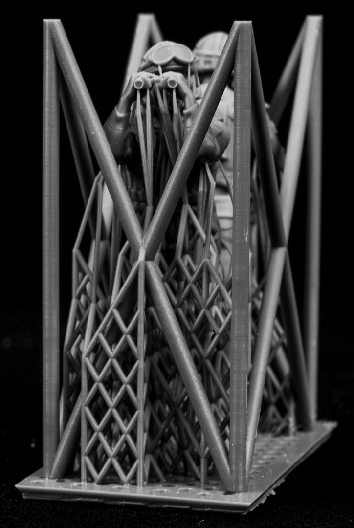 Two miniature figures of soldiers with gear inside a frame on a black background