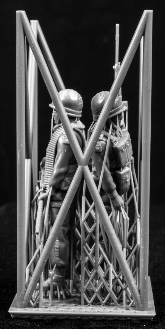 Two 3D Printed figures on a frame set on a black background.