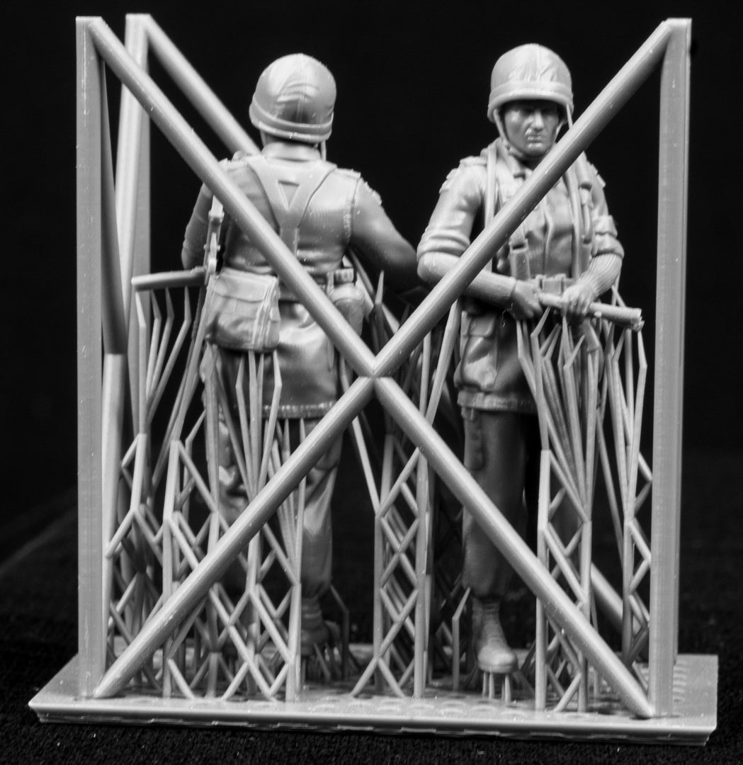 Two 3D Printed figures on a frame set on a black background.