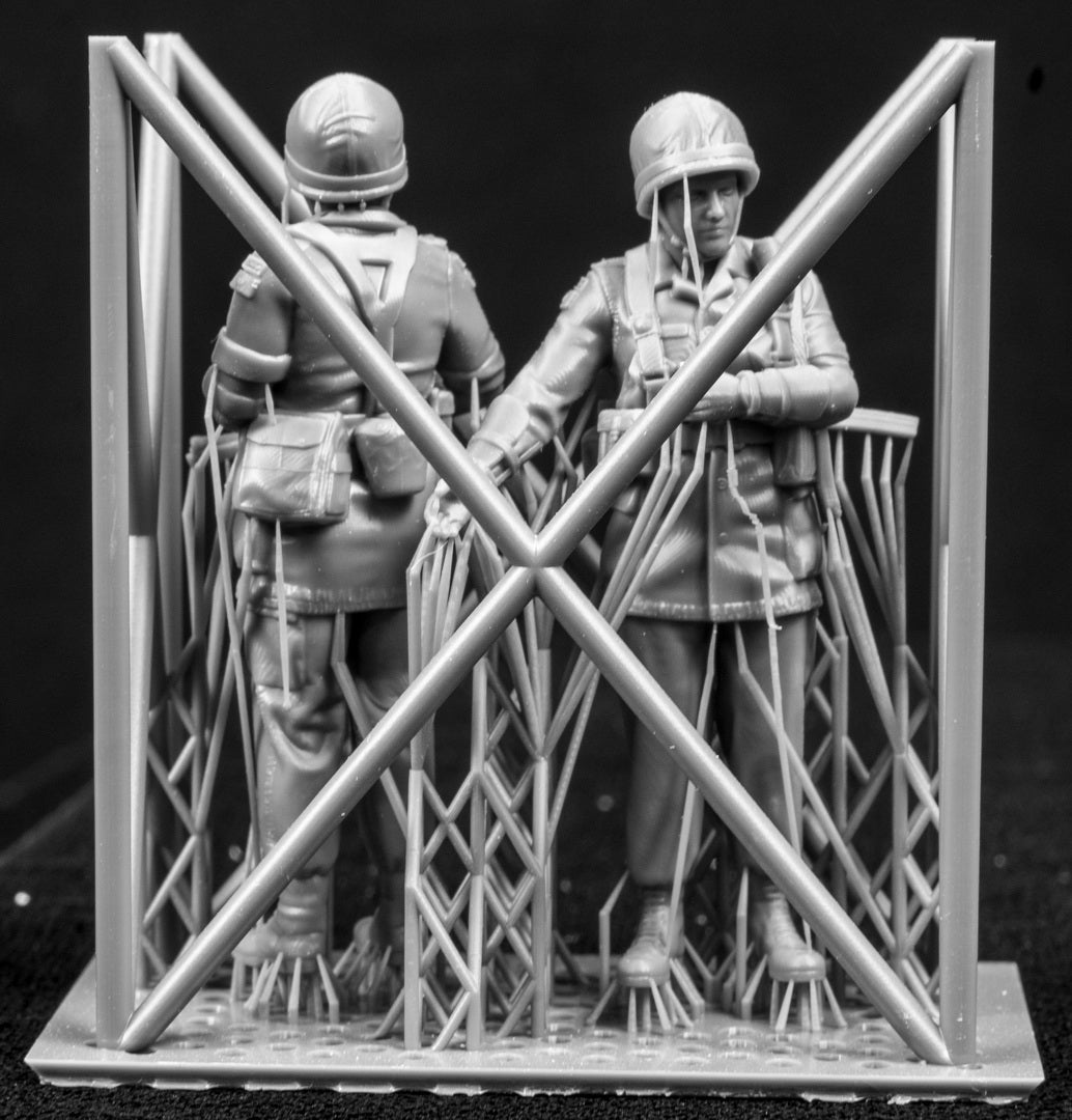 Two 3D Printed figures on a frame set on a black background.