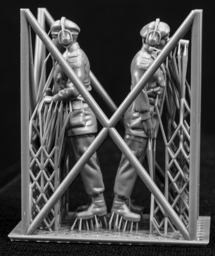 Two 3D Printed figures on a frame set on a black background.