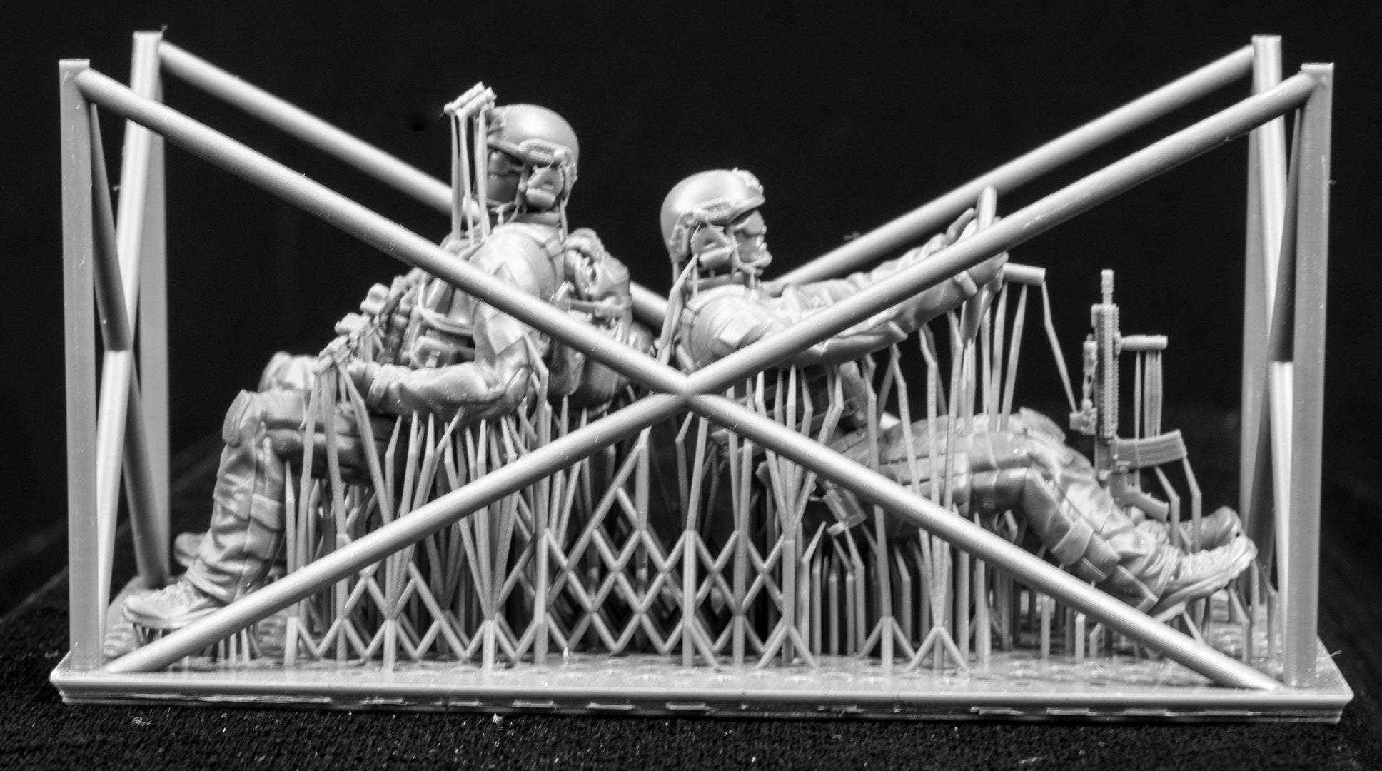 Two 3D Printed figures on a frame set on a black background.
