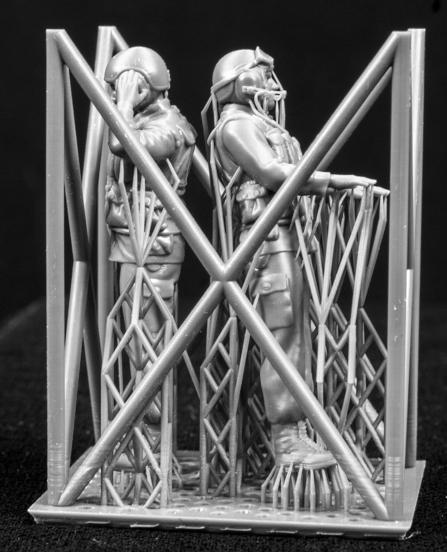 Two 3D Printed figures on a frame set on a black background.