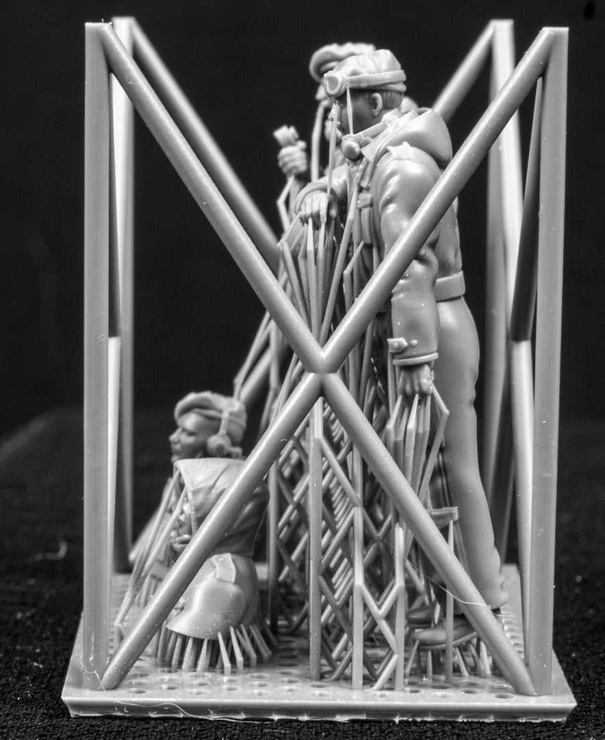 Four 3D Printed figures on a frame set on a black background.