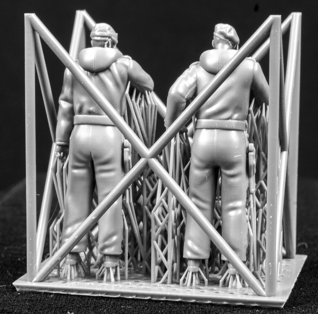 Four 3D Printed figures on a frame set on a black background.