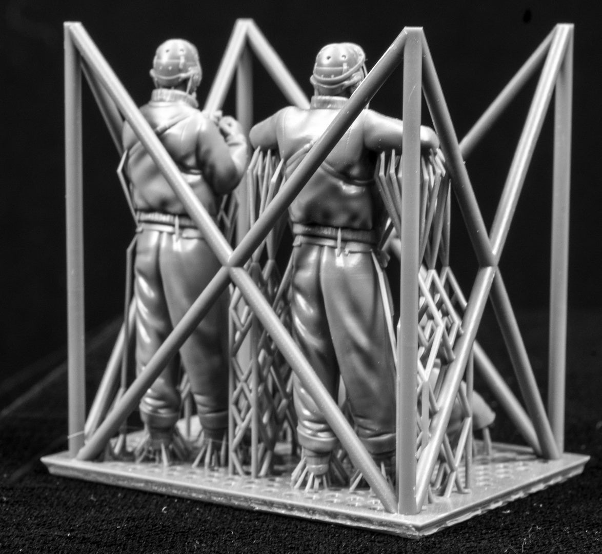 Four 3D Printed figures on a frame set on a black background.
