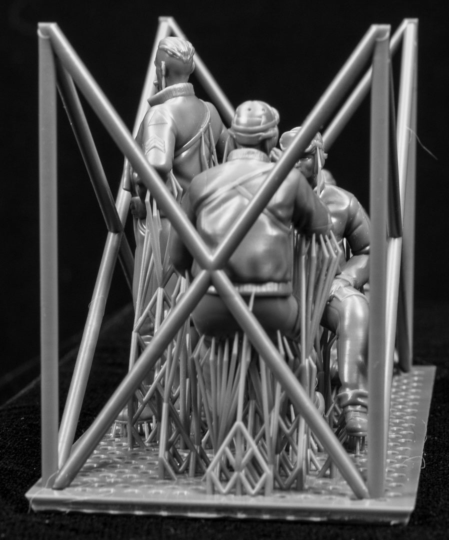 Model figures of people in tank clothing with a frame structure on a black background