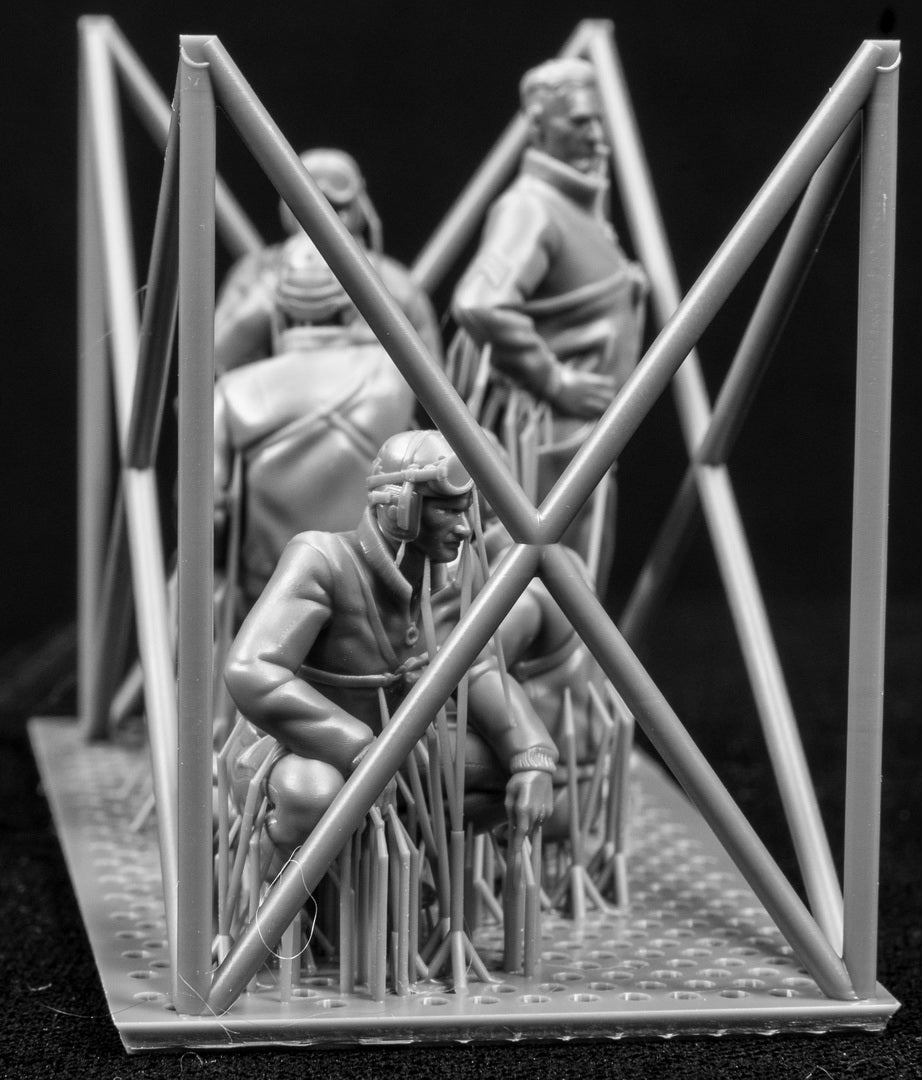 Model figures of people in tank clothing with a frame structure on a black background