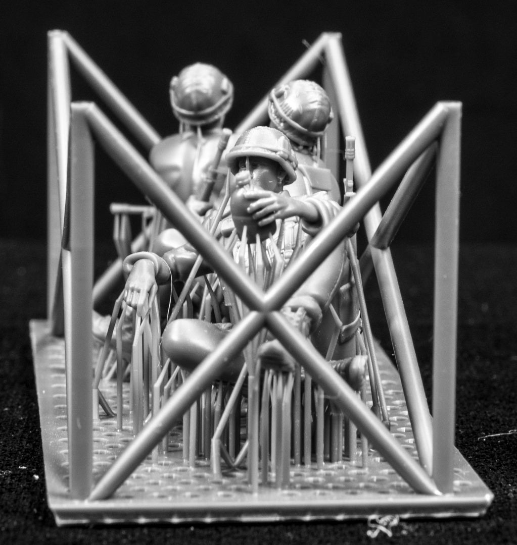 Model figures of soldiers workers behind a protective grid on a black background