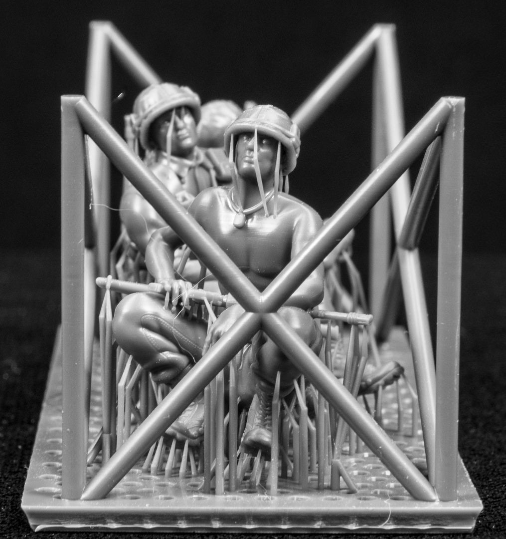 Model figures of soldiers workers behind a protective grid on a black background