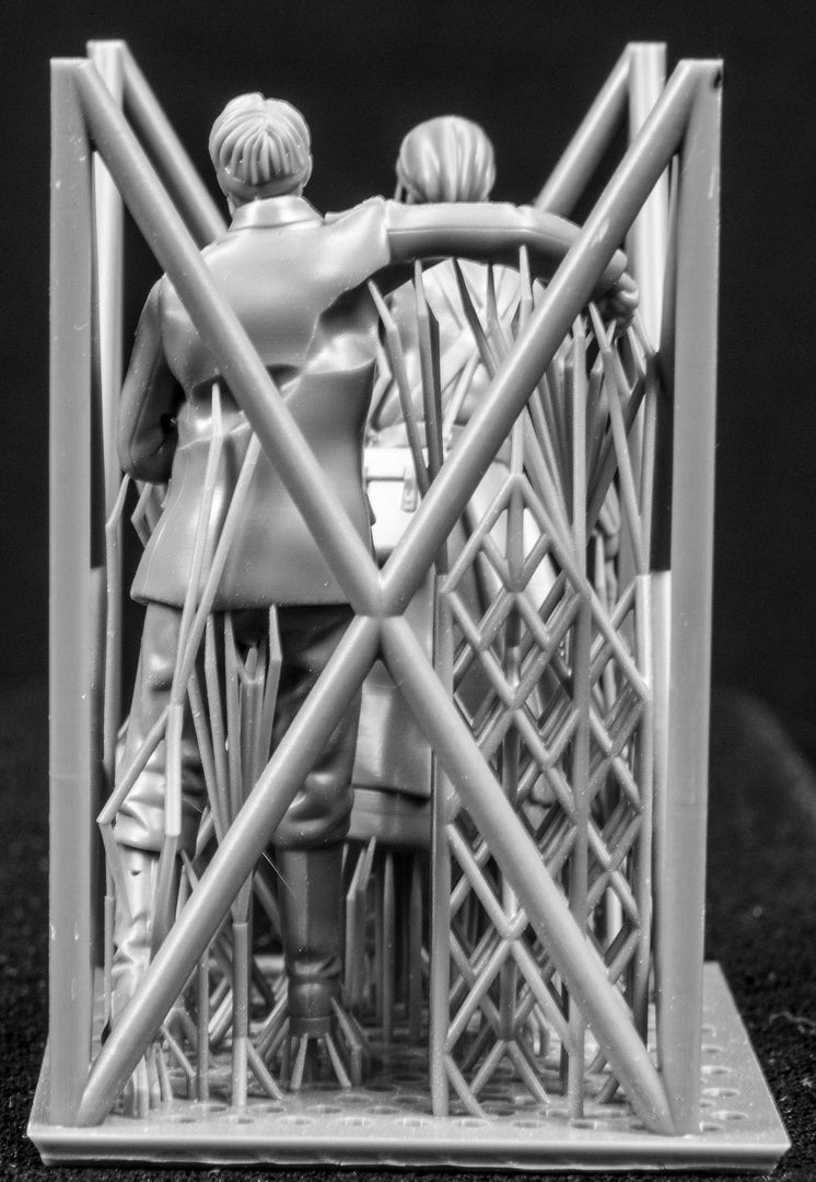 Two 3D Printed figures on a frame set on a black background.