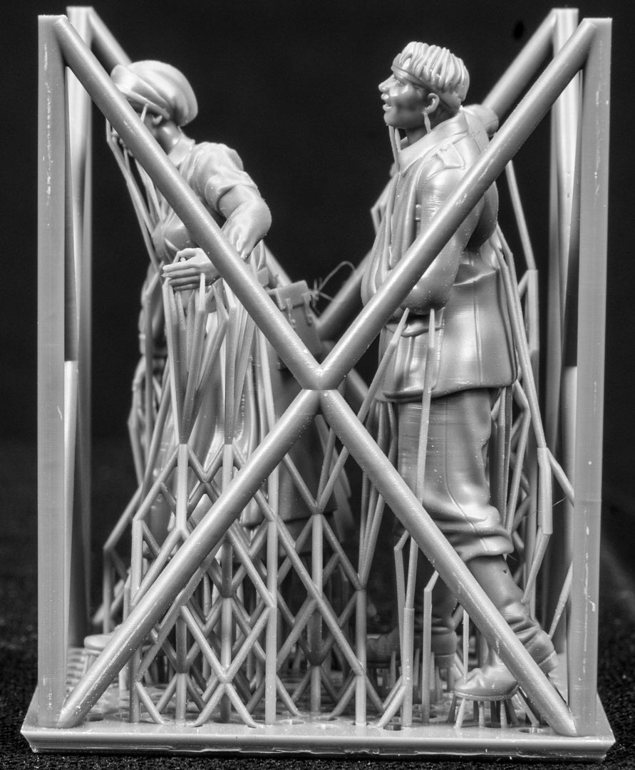 Two 3D Printed figures on a frame set on a black background.