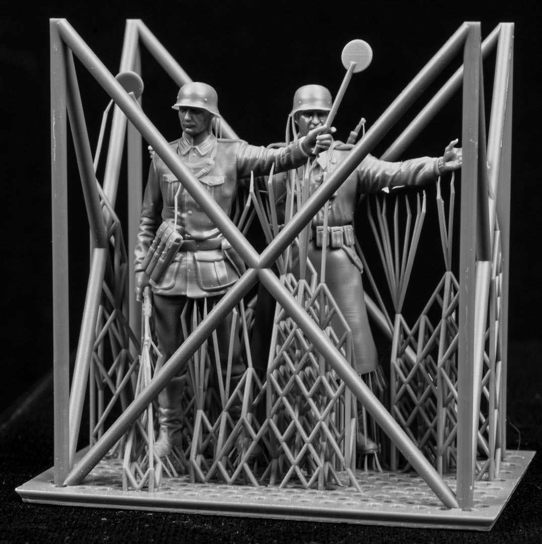 Two 3D Printed figures on a frame set on a black background.