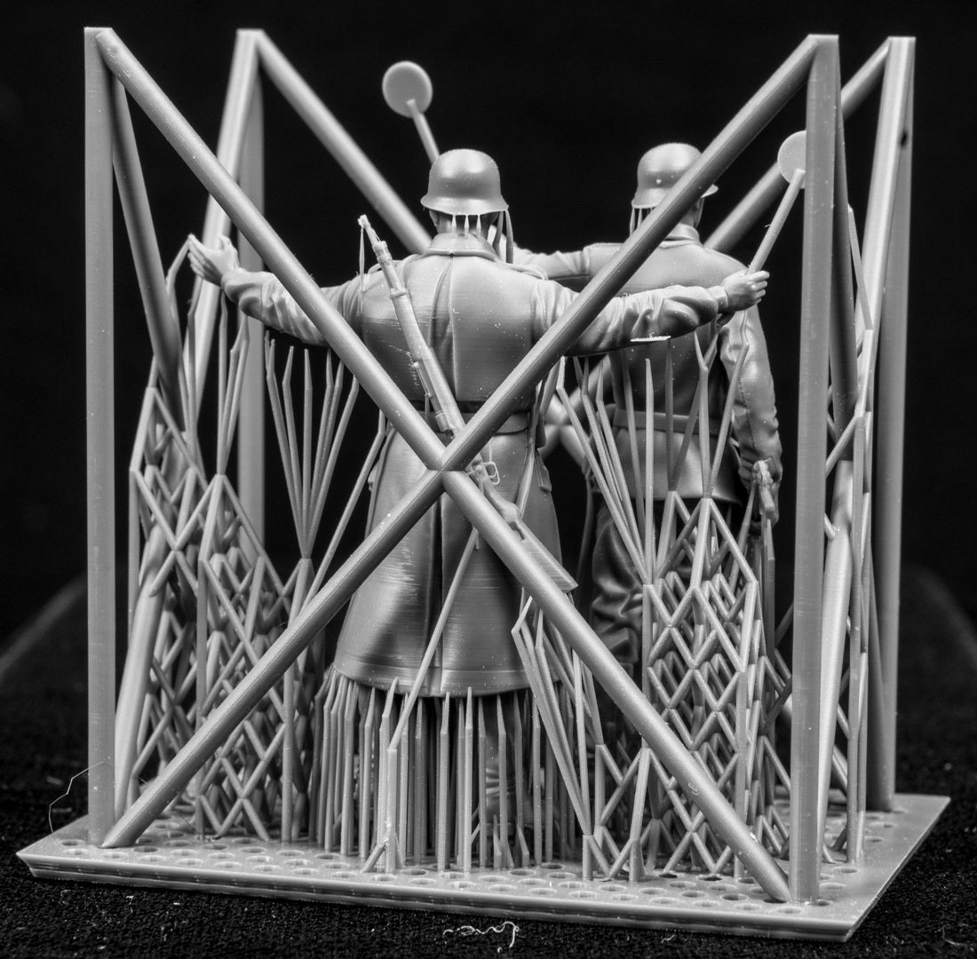Two 3D Printed figures on a frame set on a black background.
