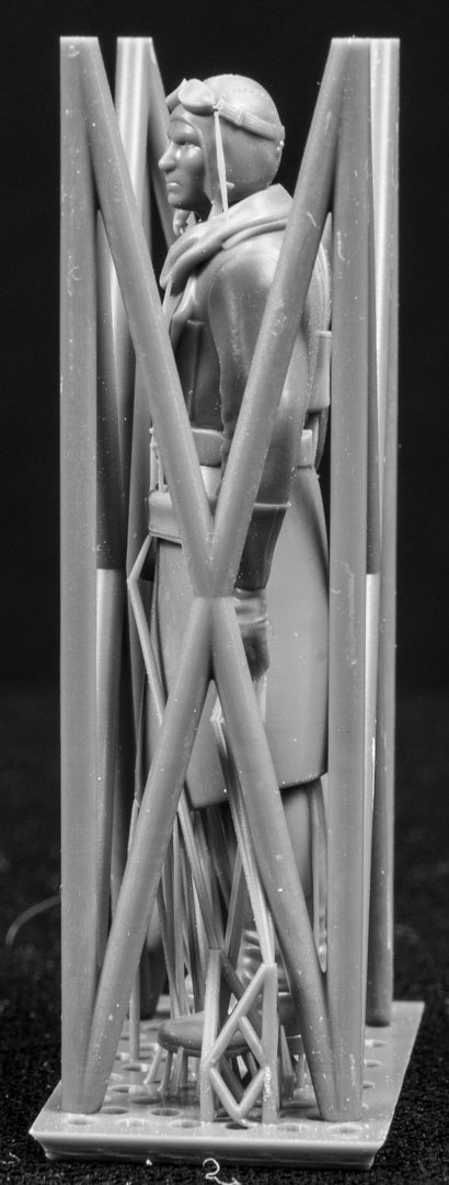 Model figure of a pilot behind a protective grid on a black background