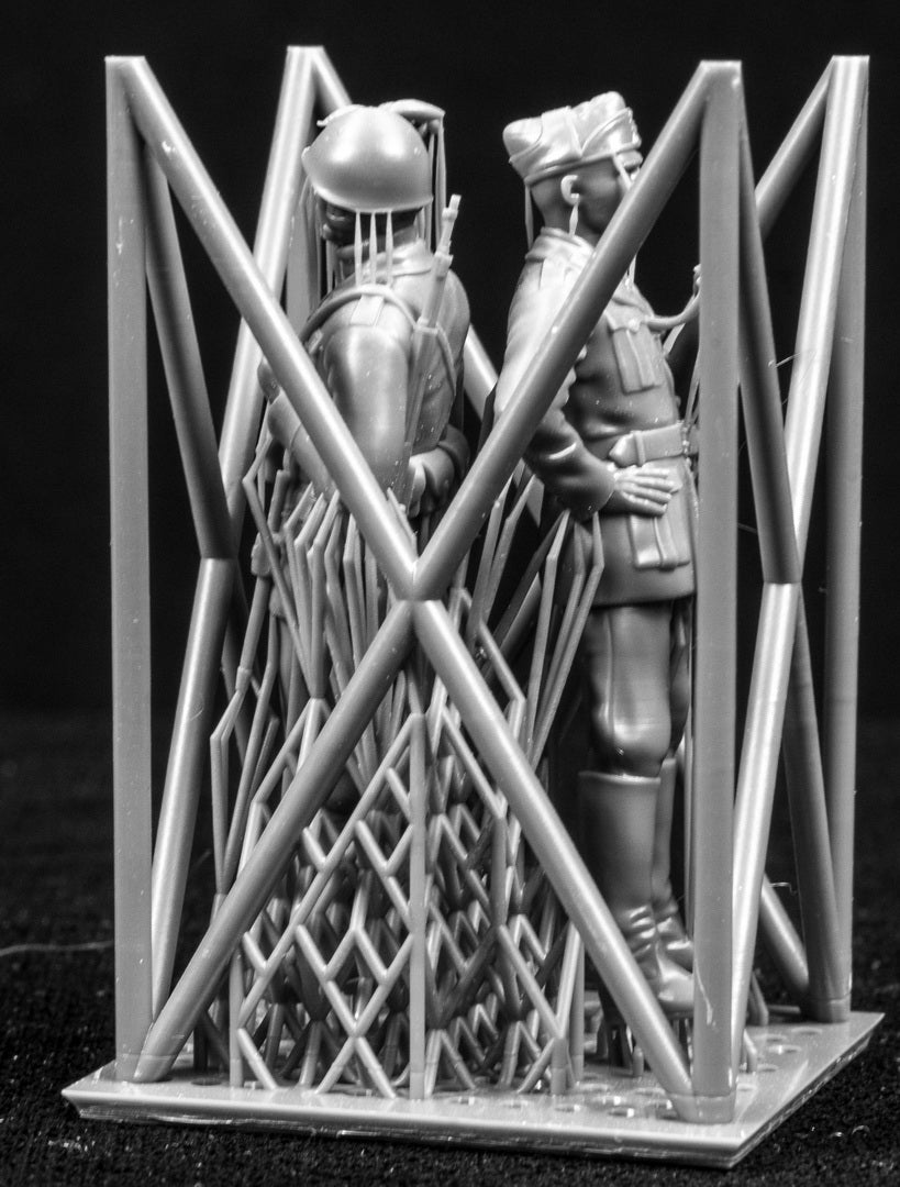 Two figures in a cage-like structure against a black background