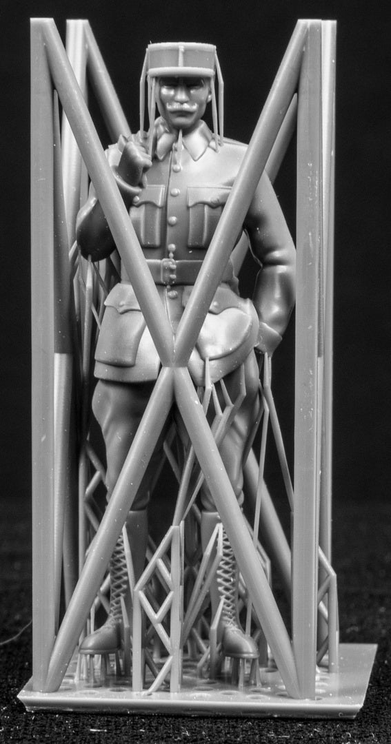 Model figure of a pilot behind a protective grid on a black background
