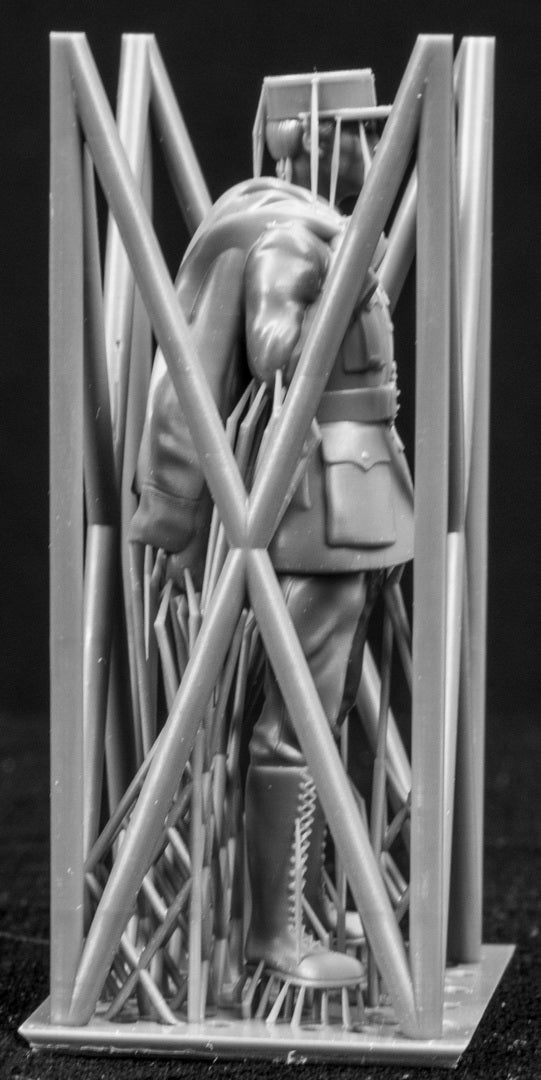 Model figure of a pilot behind a protective grid on a black background