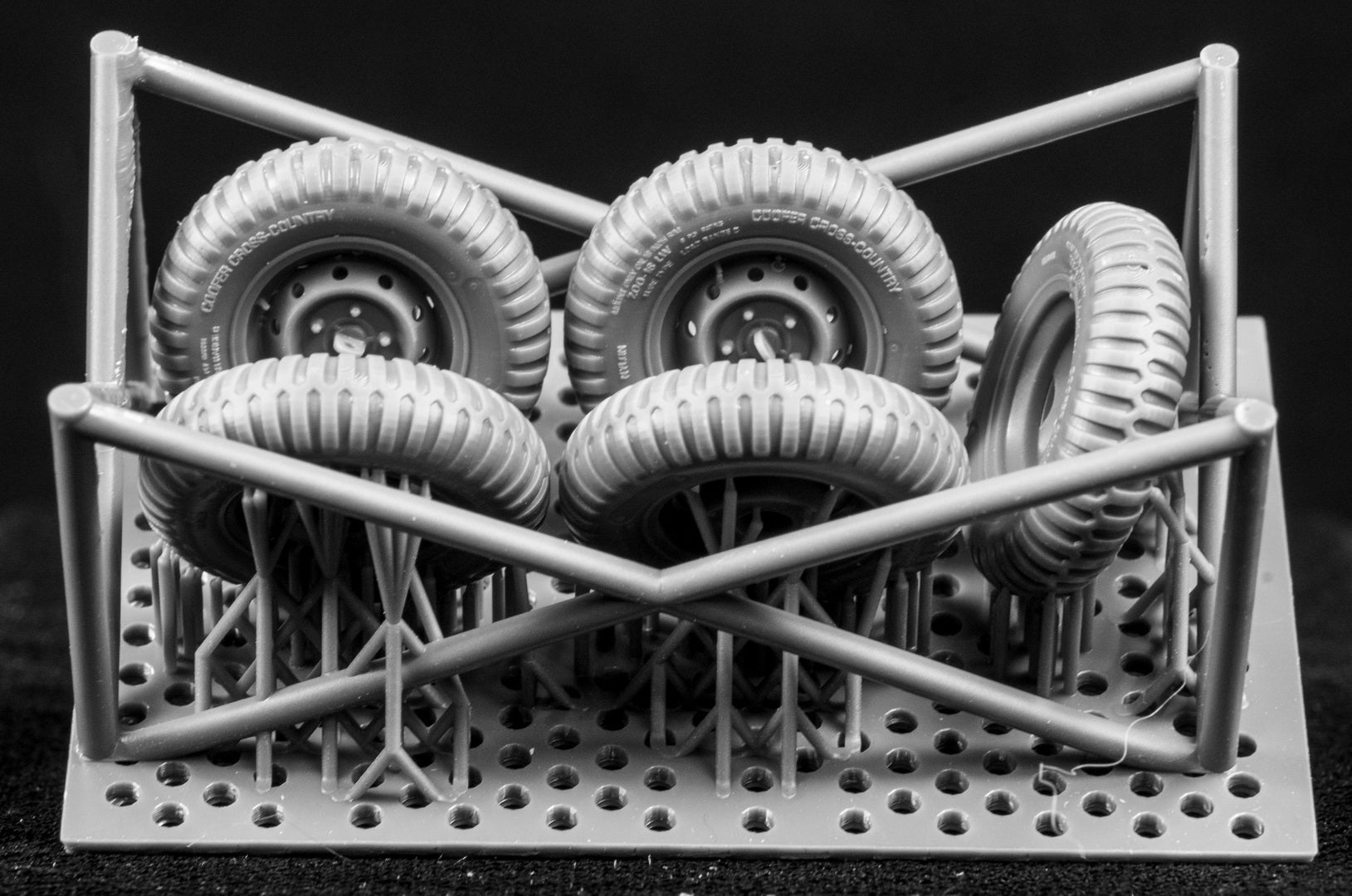Model car tires arranged in a grid on a black background