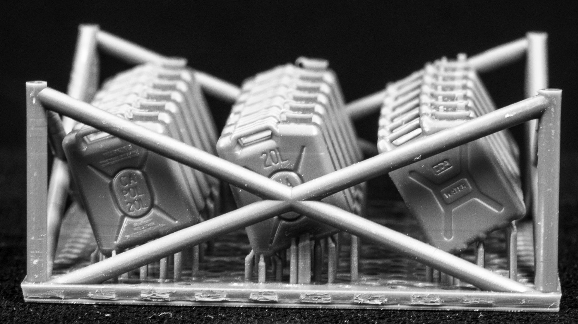 20L fuel containers in a cage-like structure on a black background