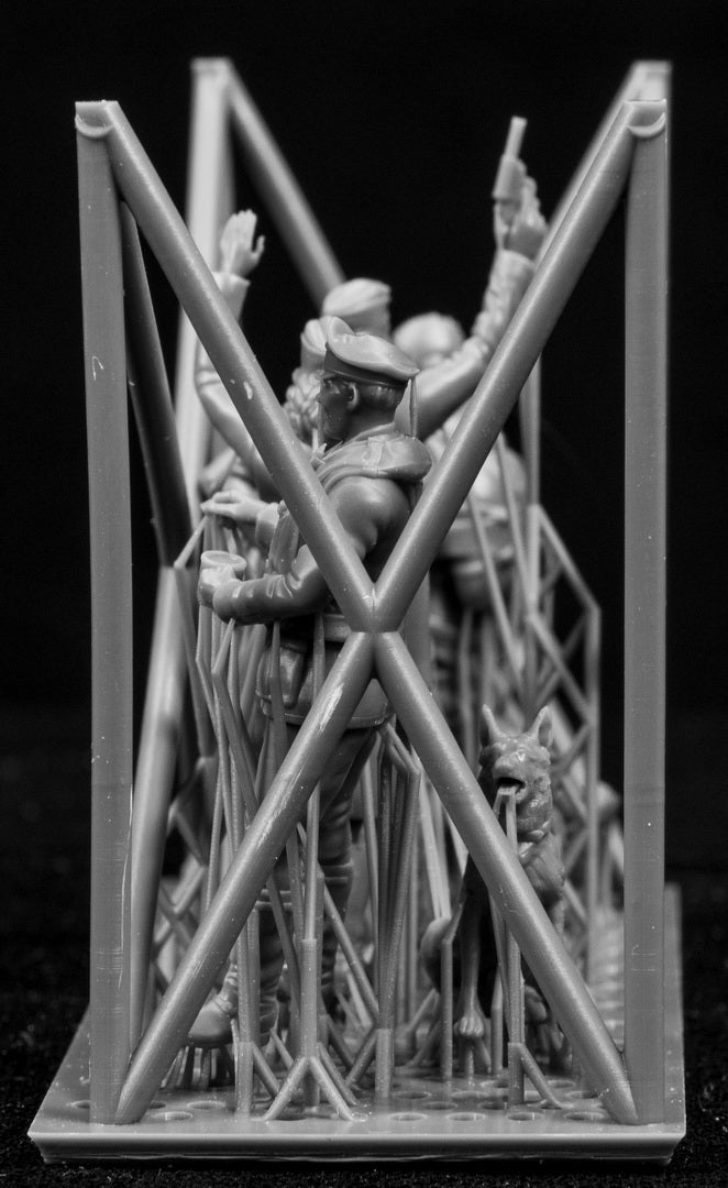 A collection of 3D printed figures on a frame with a black background.