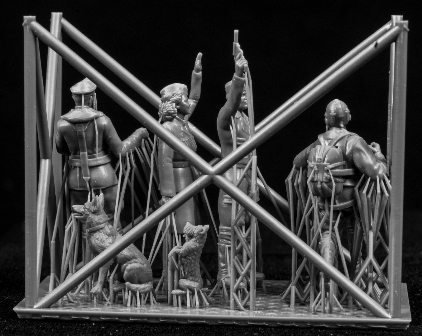 A collection of 3D printed figures on a frame with a black background.