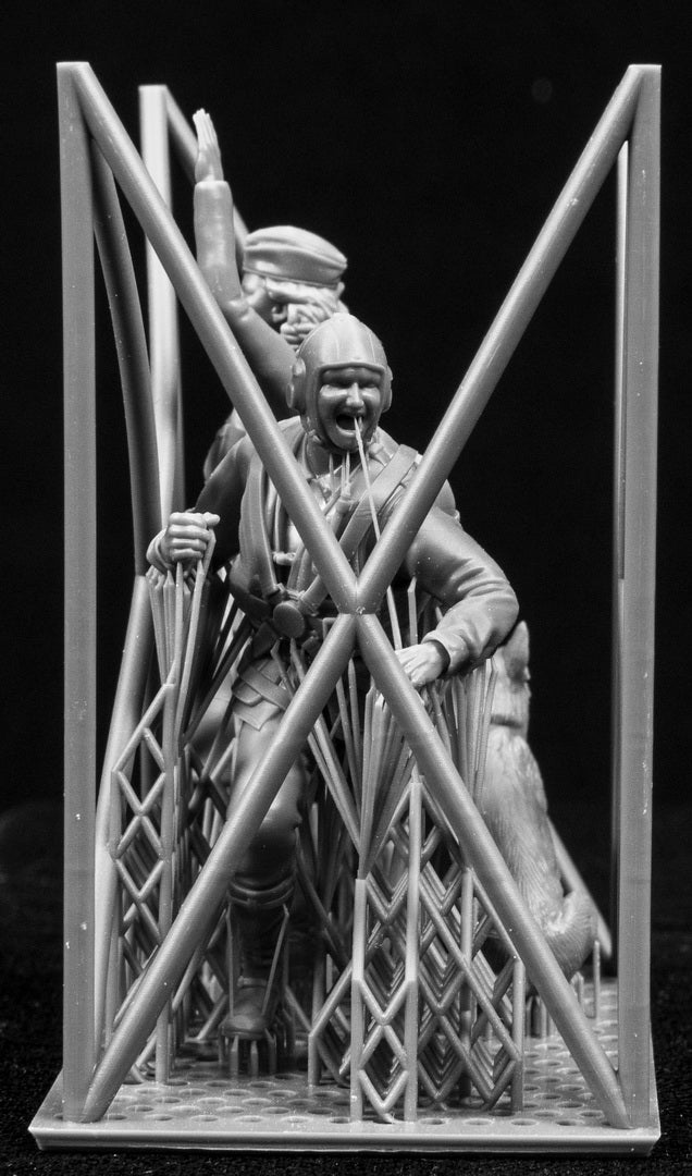 Two figurines in a cage-like structure on a black background