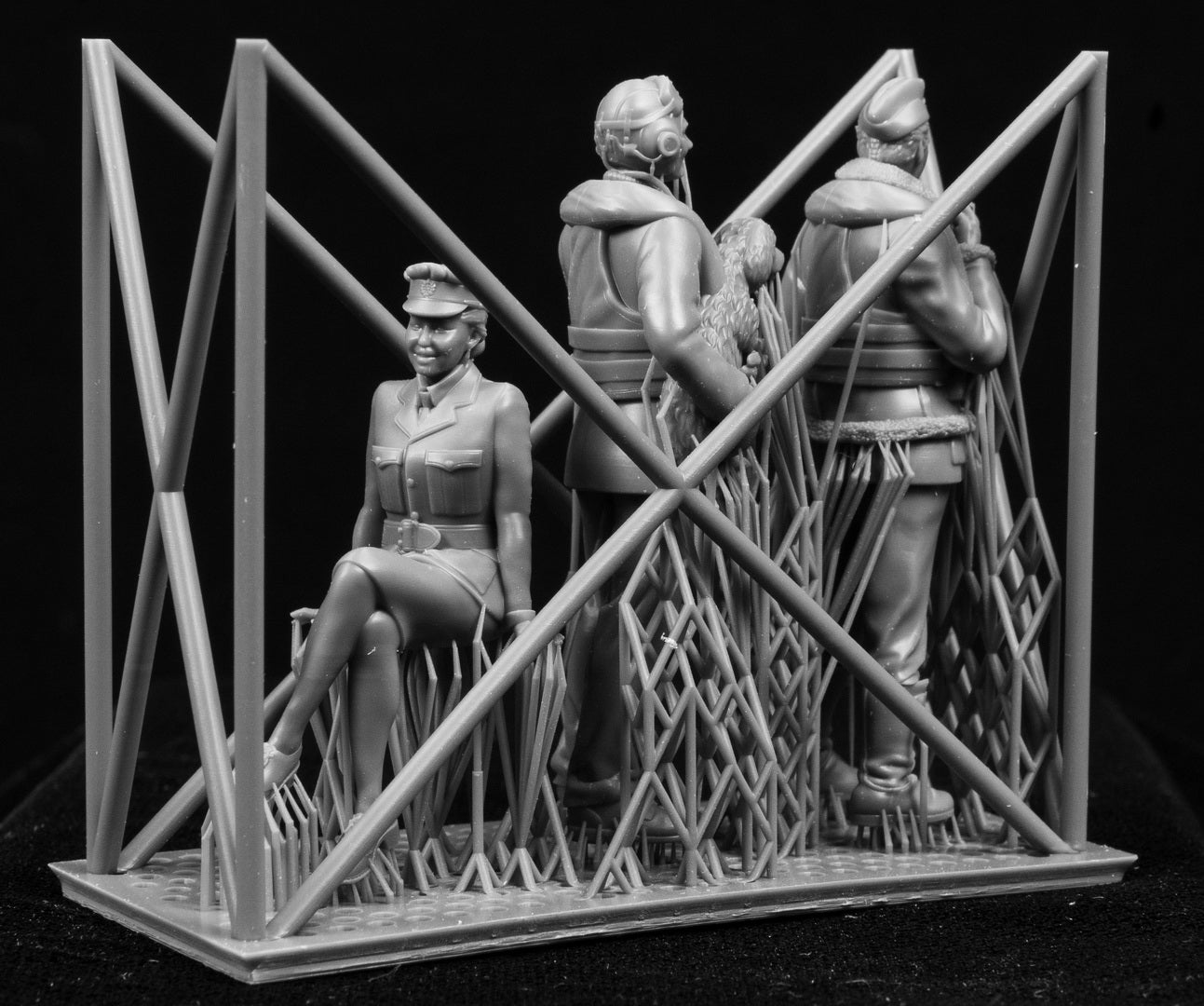 Model of a scene of figures of a 1/32 RCAF/Commonwealth Officer & WAAF behind a lattice structure on a black background