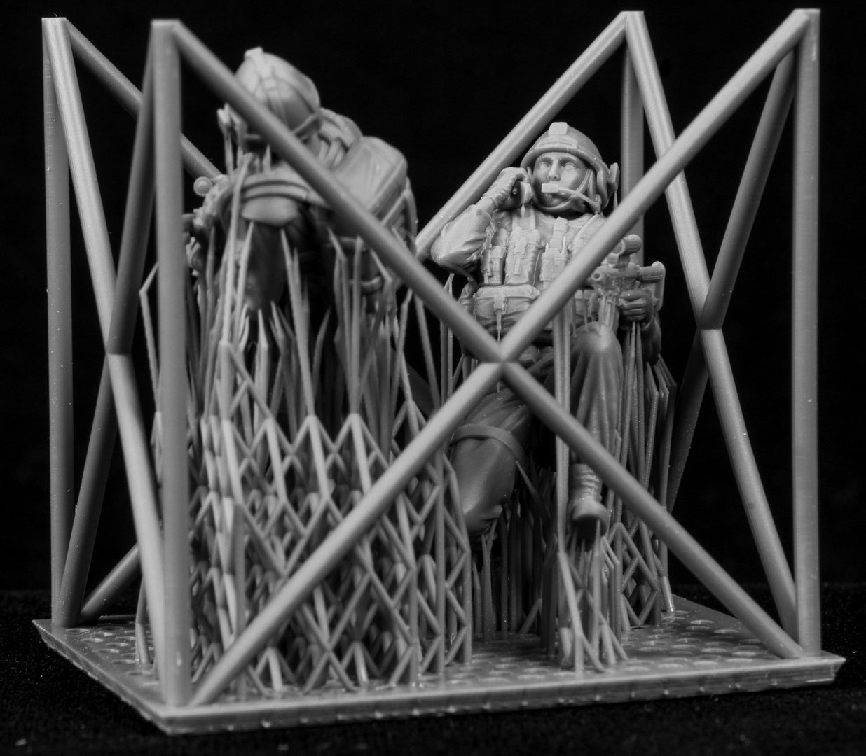 Two figures in a cage-like structure on a black background